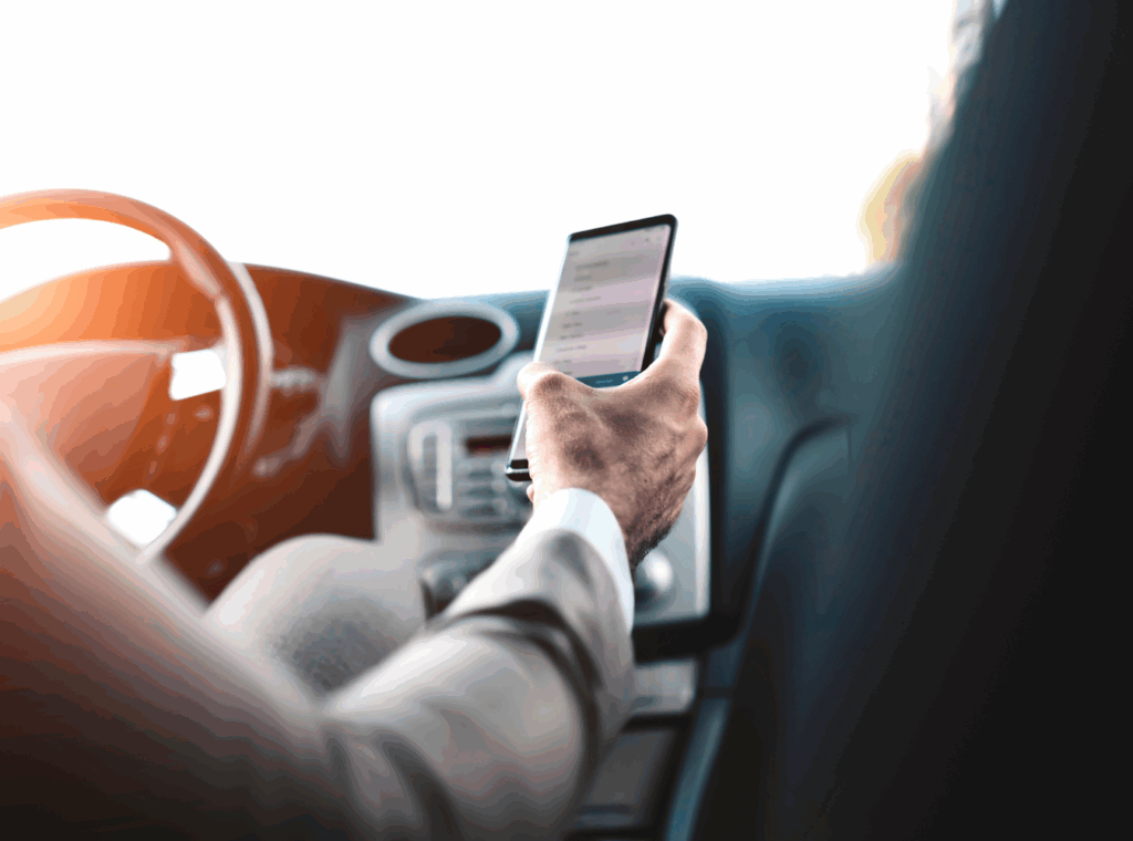 a person using a cell phone while driving a car