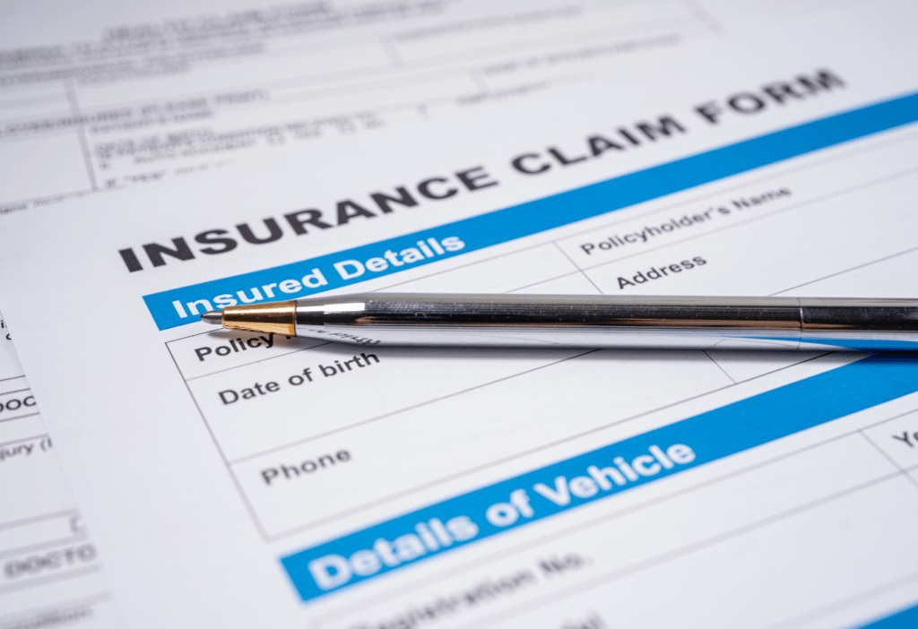 a close up photo of a pen on top of a paper that reads "insurance claim form"