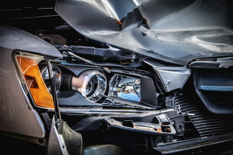 close up of a damaged front bumper and headlight