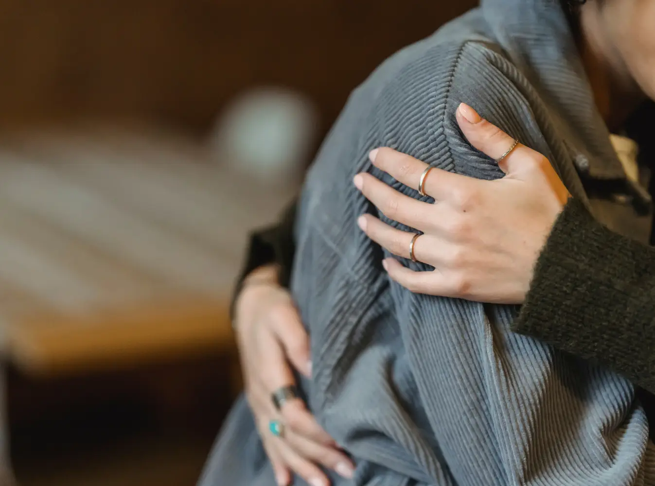 two people hugging, hands of one person are visible