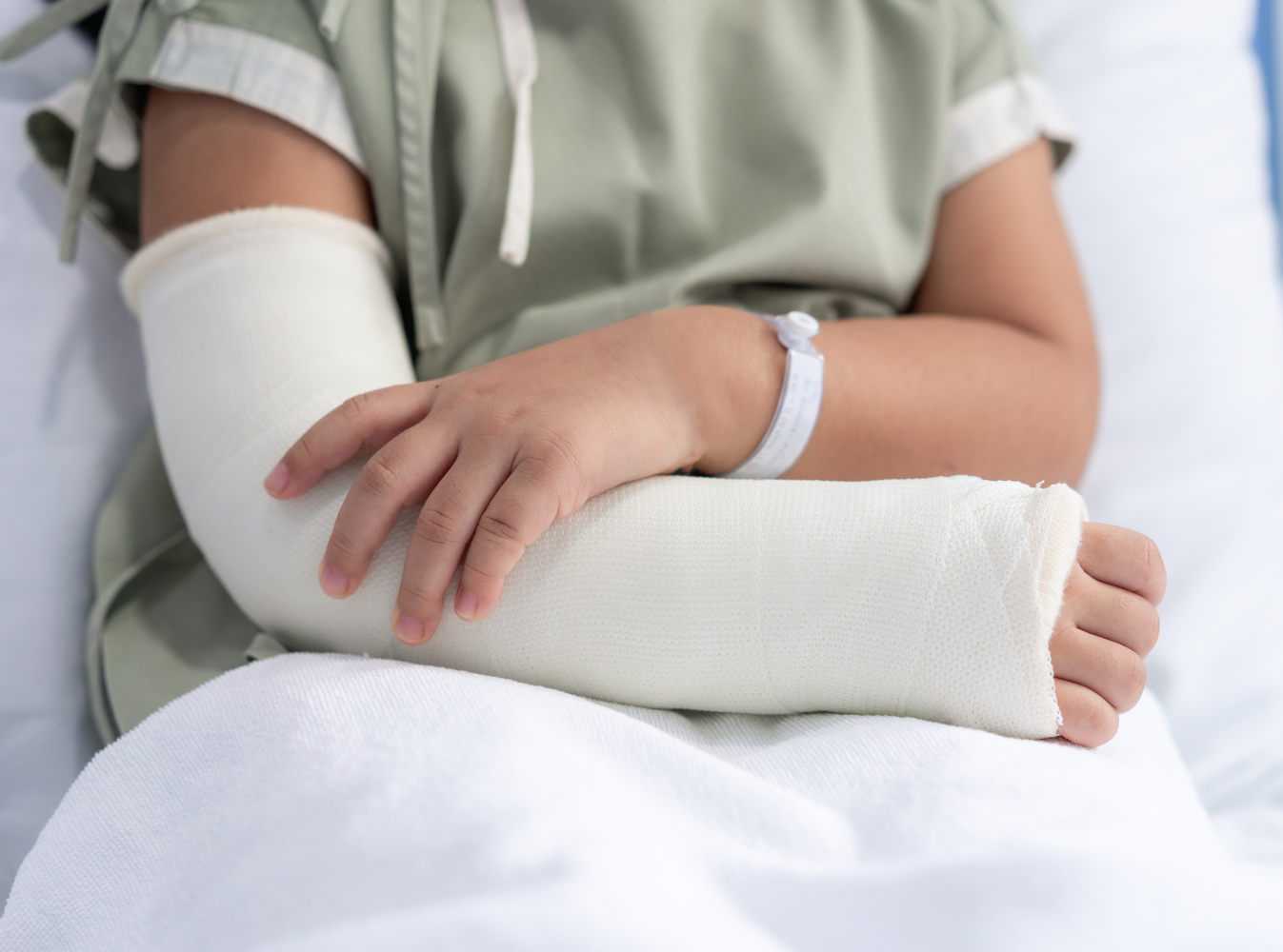 a person in a hospital bed with a cast on their arm