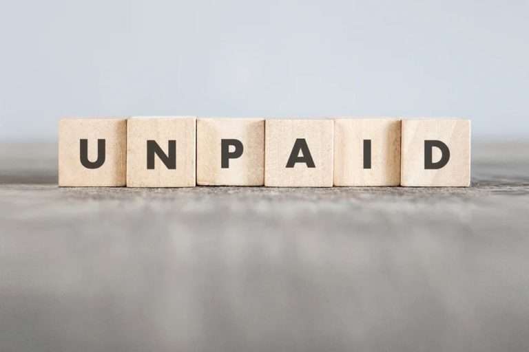 wooden blocks lined each with a letter, spelling out the word "unpaid"