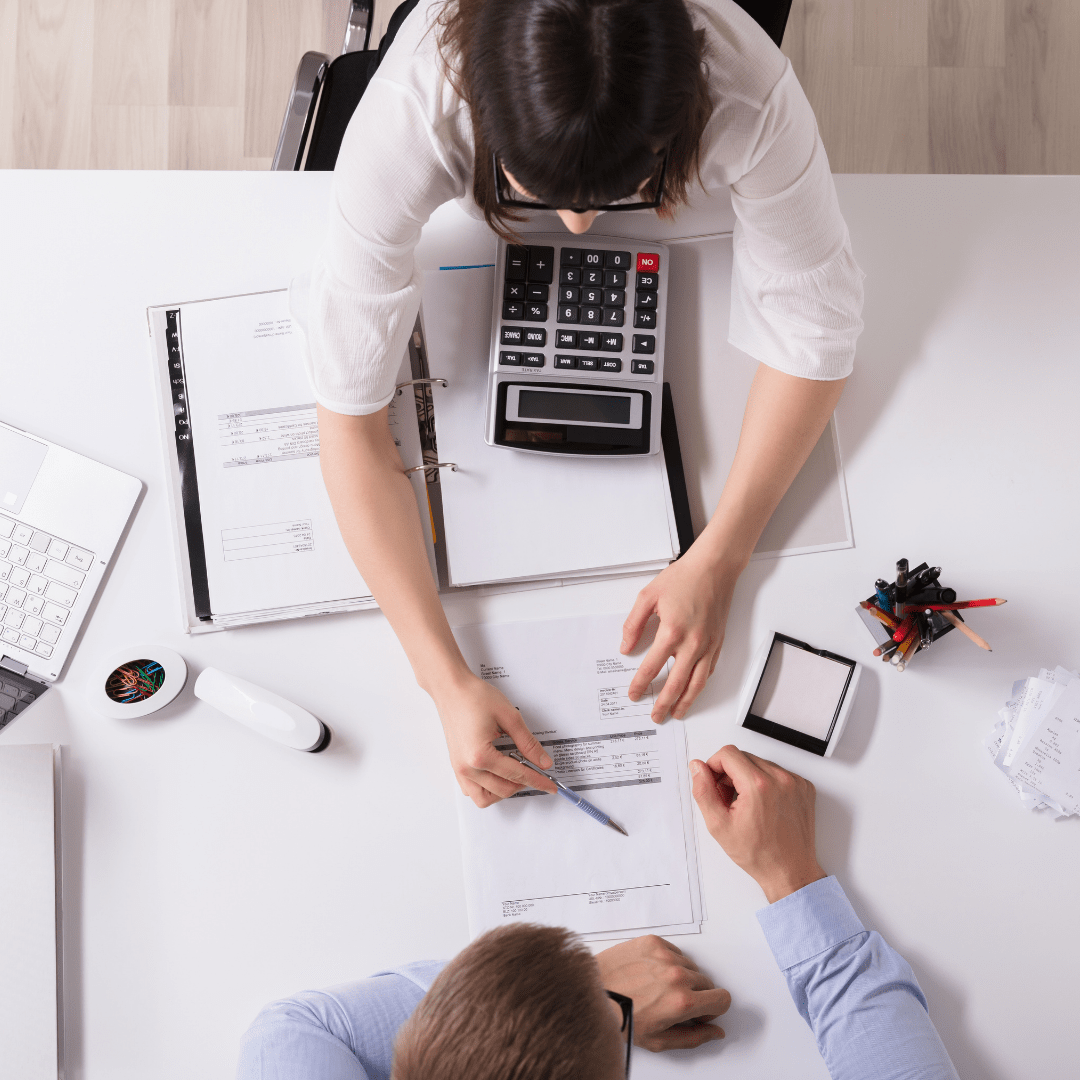 two people discussing business pov from above with calculator and documents on the desk