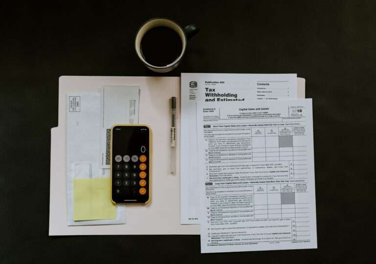 overhead image of w2s in a folder, with calculator and cup of coffee above
