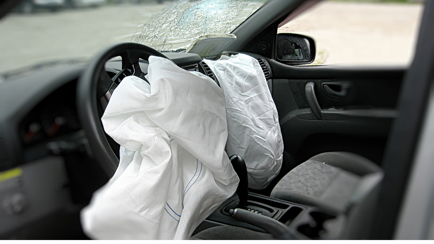 a car dashboard with deployed airbags