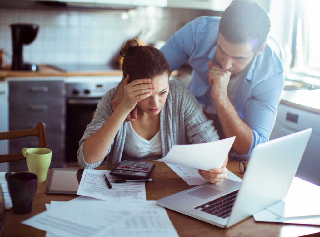 two people viewing bills and a computer