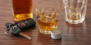 keys next to a bottle and glass