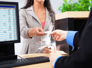 person handing a check to a bank teller navy federal credit union