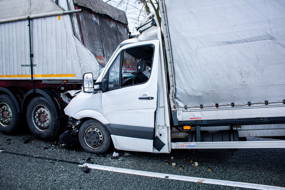 Multi-vehicle truck accident scene with a van impacted by a semi-trailer, illustrating liability issues in North Carolina