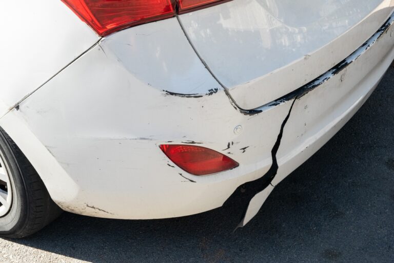 Cracked and scuffed rear bumper after a minor speeding accident in Raleigh