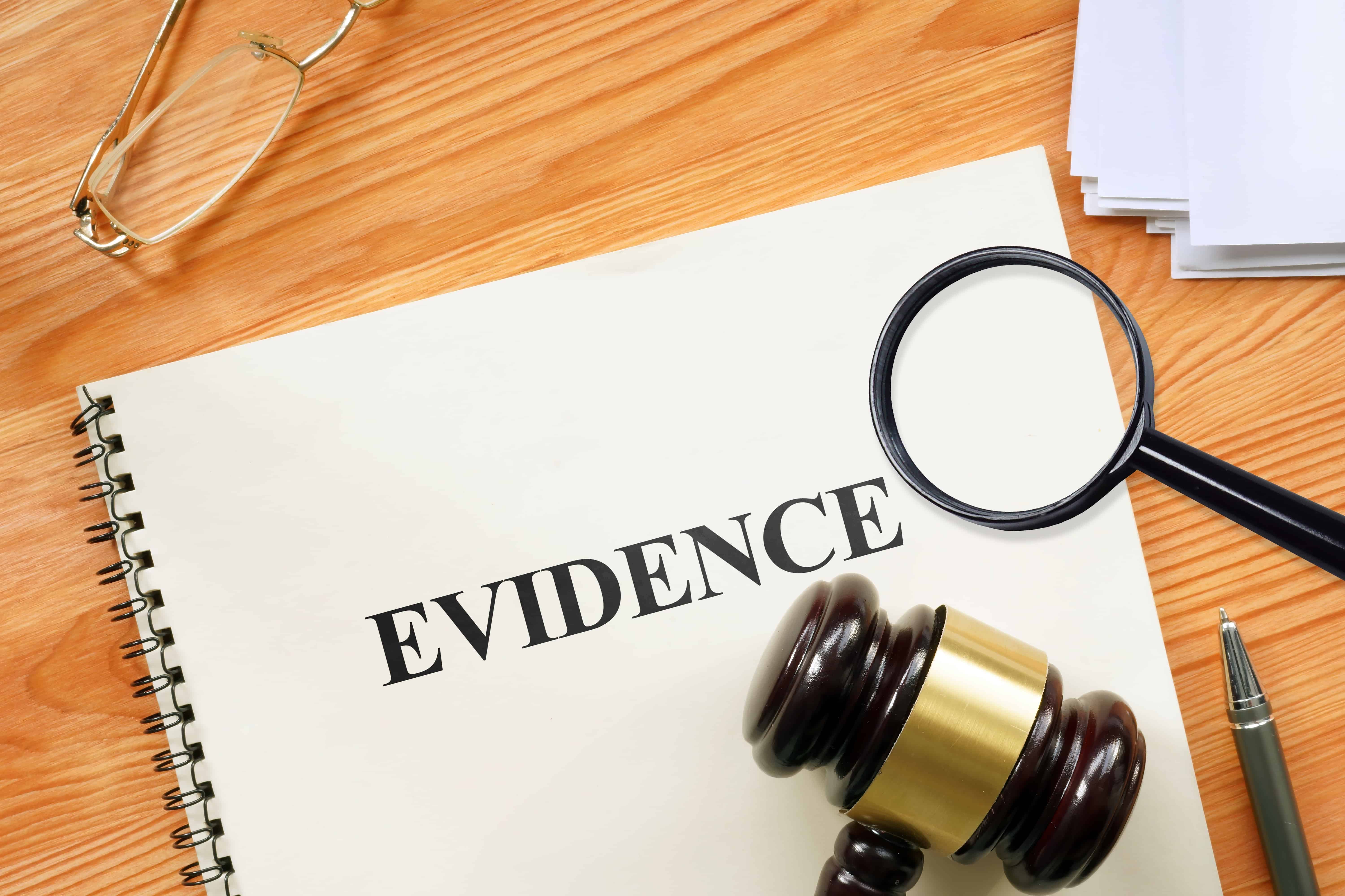 Legal evidence folder with gavel and magnifying glass on desk