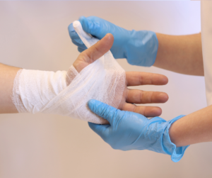 medical professional wrapping a person's hand in gauze bandages