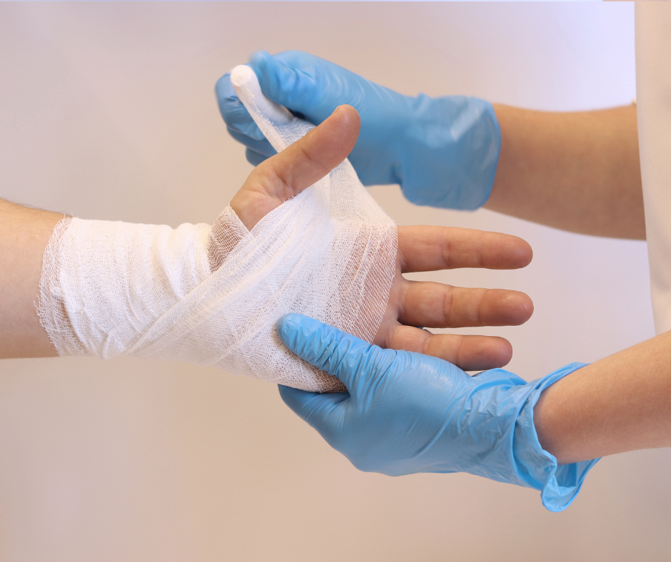 medical professional wrapping a person's hand in gauze bandages
